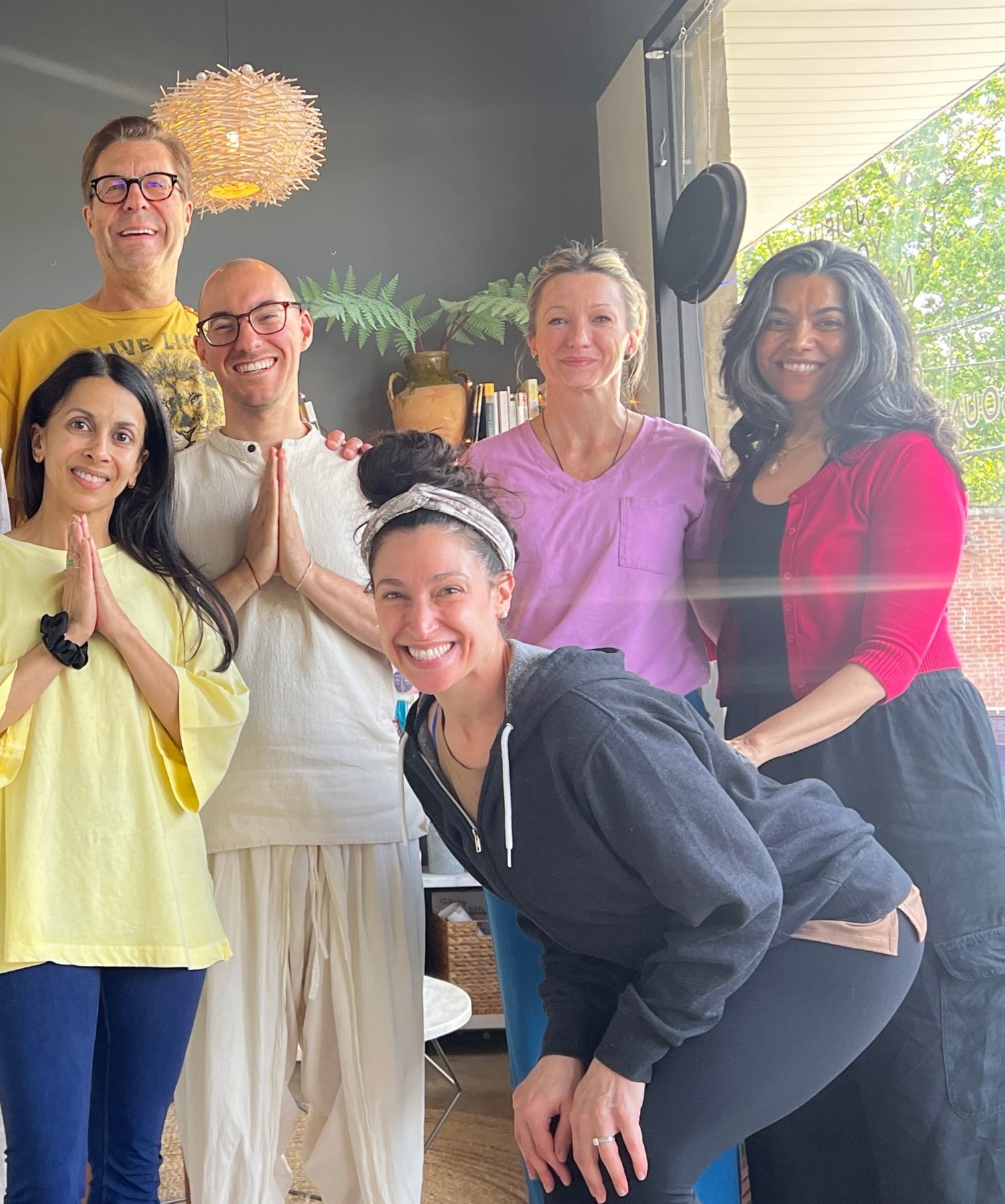 A group of students smiling with hands at heart center
