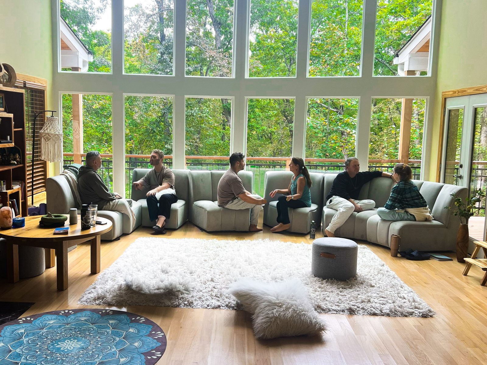 A circle of participants in warm conversation in a light-filled space