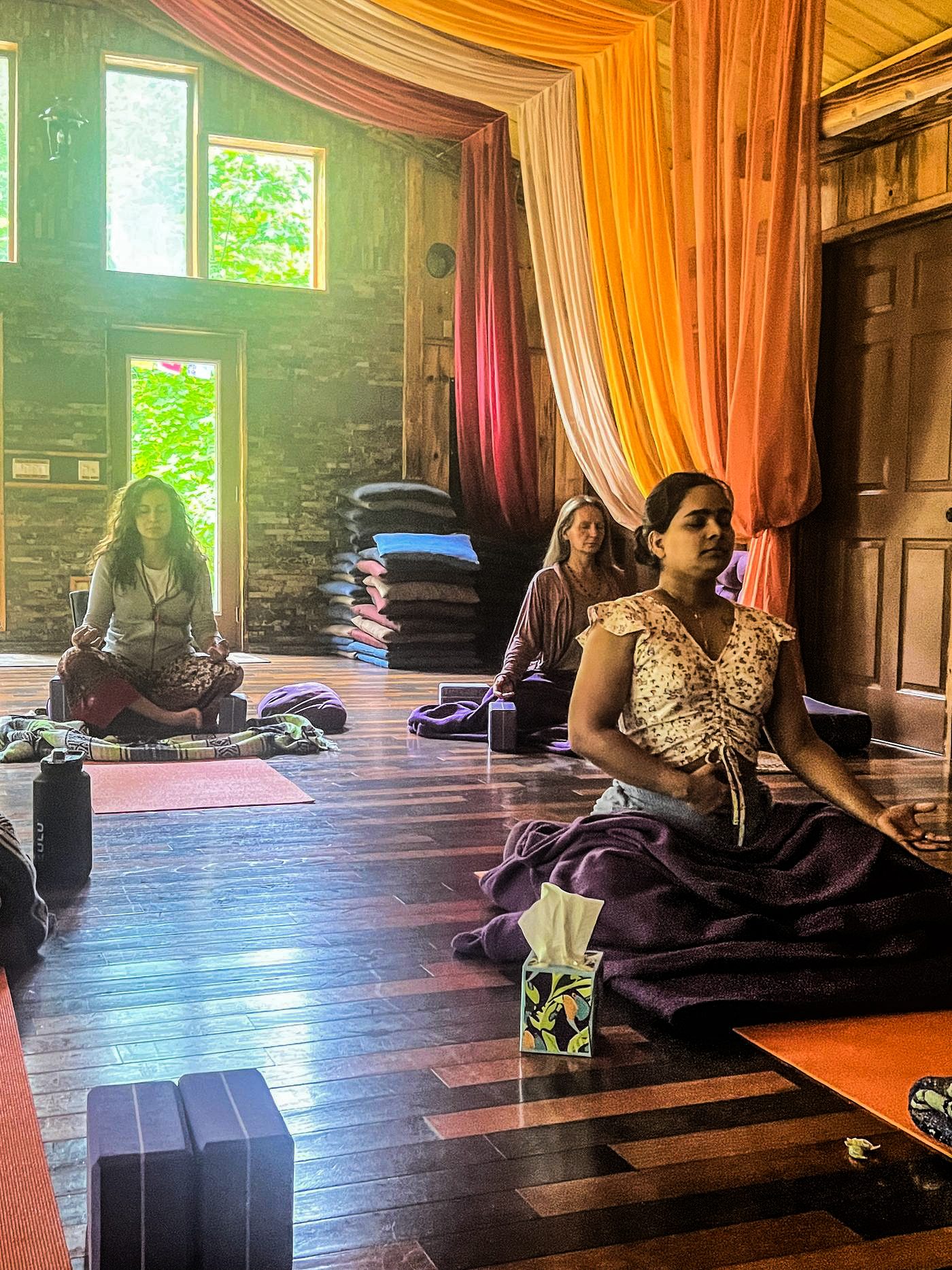 Practitioners seated in stillness, meditating in warm light