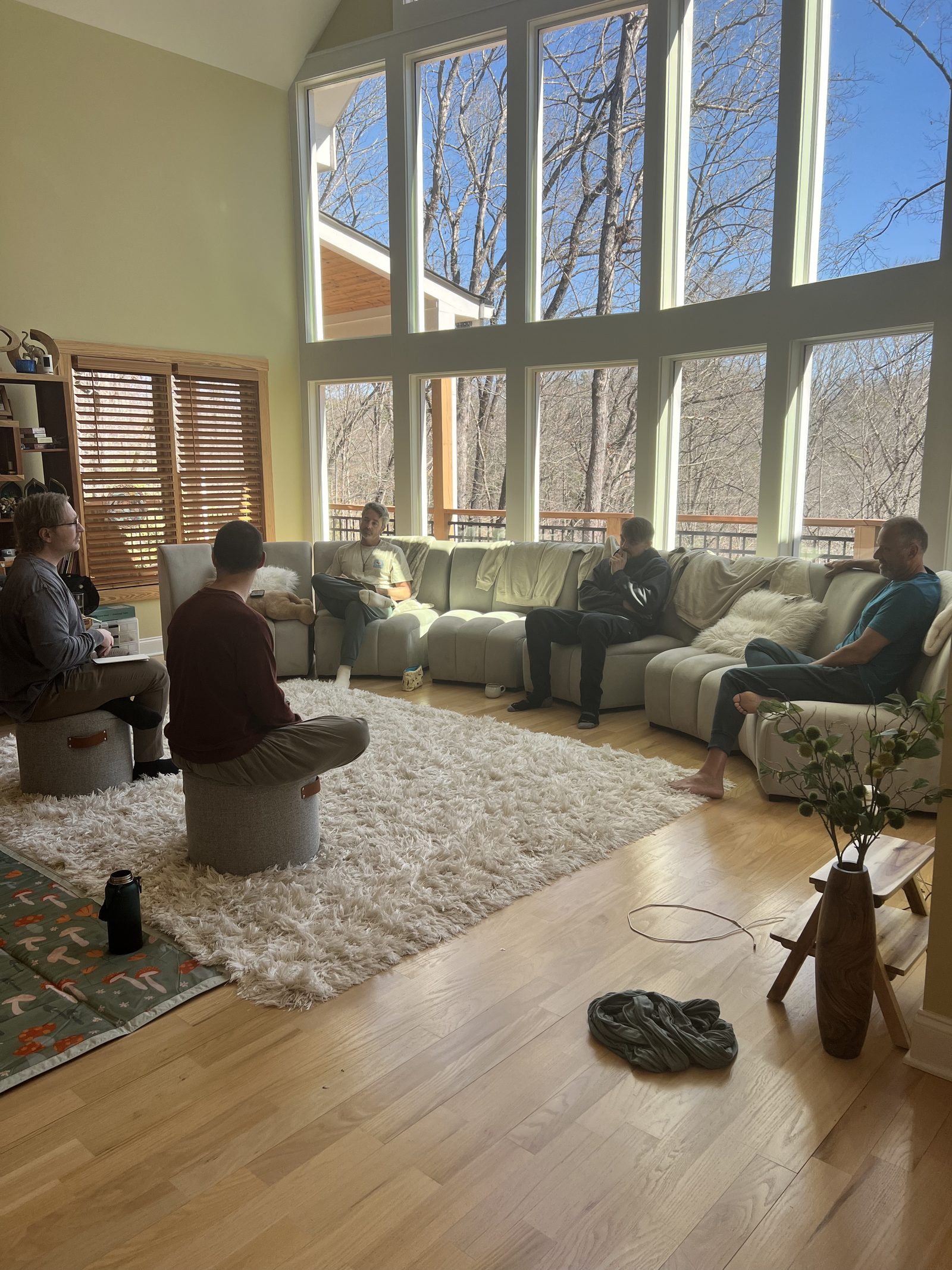 A men's circle gathered in conversation in a sunlit cabin